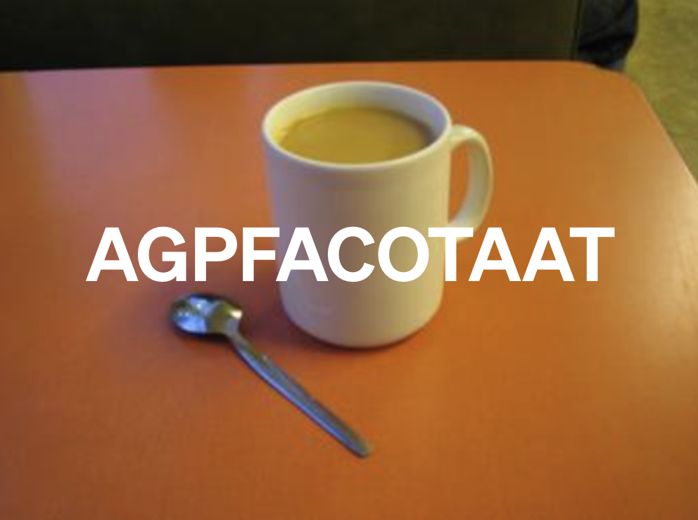 A mug of tea and a tea spoon on a red formica table
