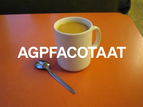 A mug of tea and a tea spoon on a red formica table